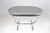 A French mid-century modern extendable kitchen dining table from the 1960s, with an oval Formica top and slender chrome-...