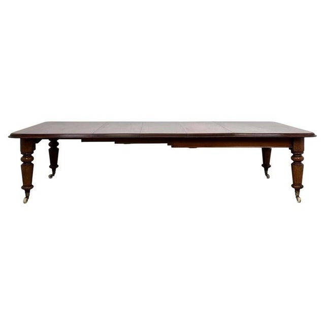 An exceptional large 19th-century English Victorian dining table, finely constructed in mahogany and distinguished by its...
