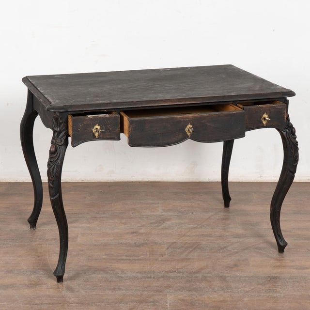 Late 19th-century Swedish pine desk with an old black painted finish that has been distressed over time. The desk features...