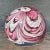Pink and white paperweight with a flower built around a Millifiore center. The bottom is nice and clear and there are...