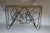 Imported from Belgium, this striking vintage console is defined by its sculptural squiggle iron base with an organic,...