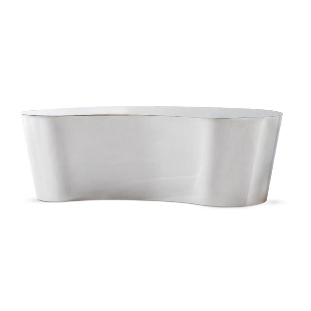 Strikingly sculptural, this polished nickel cocktail table captures movement in metal. Its fluid, organic silhouette...