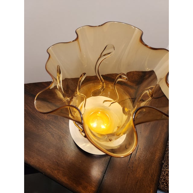 A striking mid-century Venetian art glass vase featuring a warm amber body, a dramatic hand-scalloped ruffled rim, and...