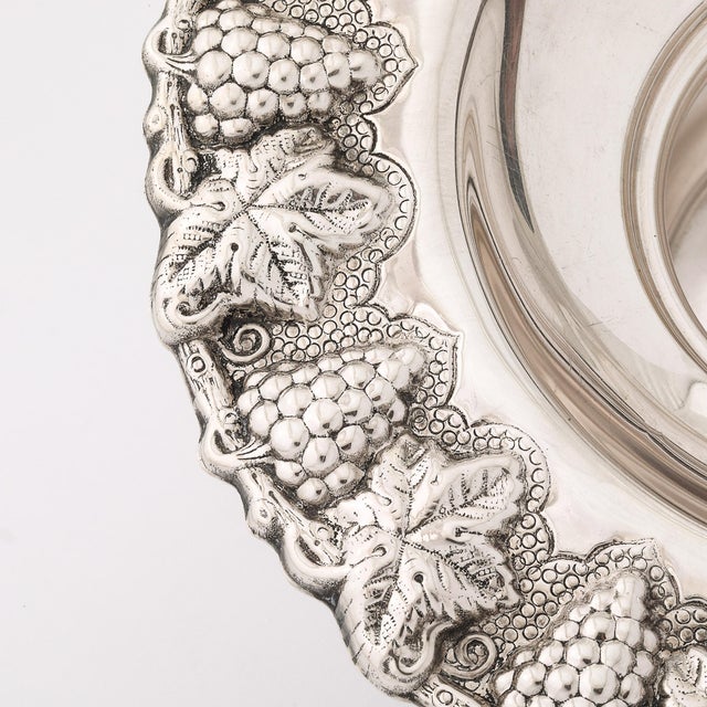 This sterling silver mayim achronim set, crafted in Israel during the 20th century, showcases a beautifully detailed grape...