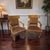 A distinctive pair of vintage armchairs featuring sculptural wood frames, upholstered accent seating, and classic wood...