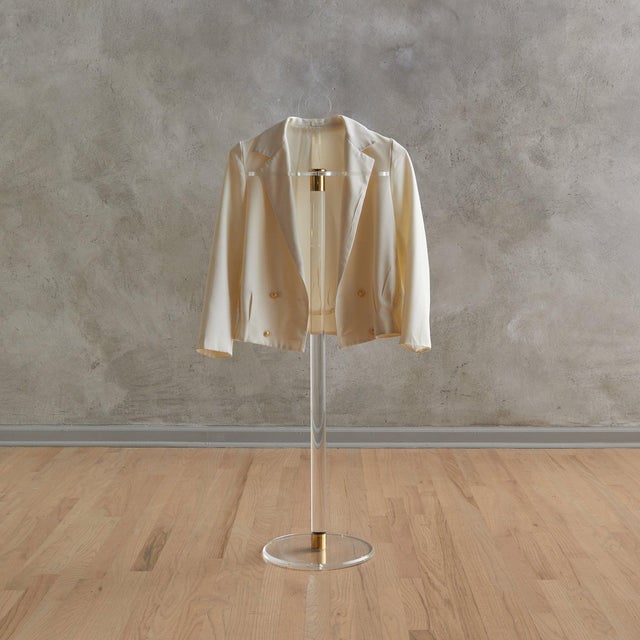 An Italian valet from the 1970s, crafted in clear plexiglass with polished brass fittings. The silhouettea hanger poised...