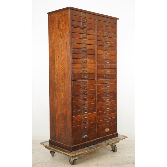 Early 20th century oak storage cabinet with forty eight drawers, twenty four to a side. Likely used as index card or...