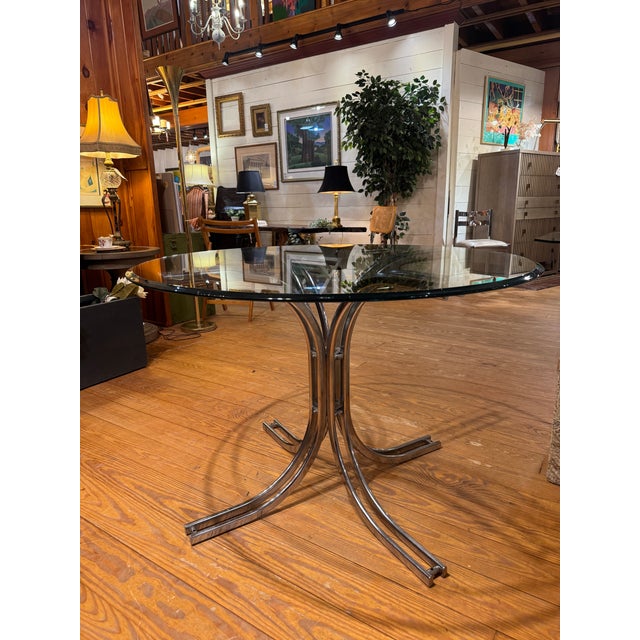 1970’s Modern Glass top table with silver Chrome base. The table is a Space Age design from the 1970s, likely of Italian...