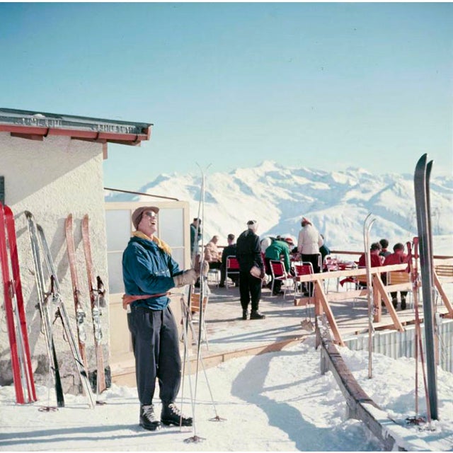 Mountain Top by Toni Frissell A skier checks their skis at a mountain top terrace, Klosters, Switzerland, 1951. (Photo by...