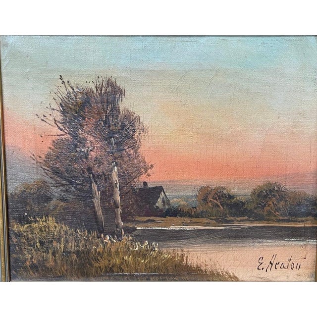 Signed oil on canvas landscape by Edward Heaton, depicting a quiet rural waterside scene with a cottage, windblown trees,...