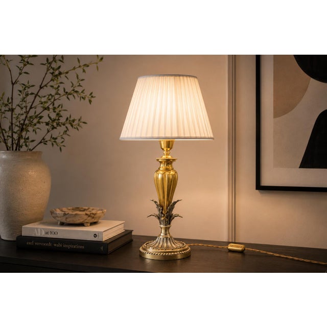 Decorative table lamp dating to circa the 1960s, combining a fluted gold-toned brass body with a contrasting silver-toned...