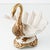 Weighty sculptural swan bowl in white crackle-glazed porcelain with gilt metal accents. The elongated neck and modeled...