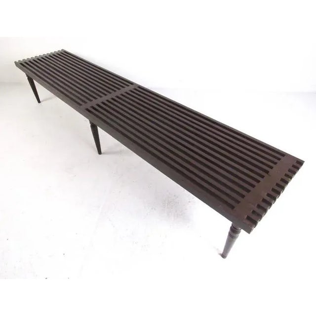 This vintage handmade wood slat bench features six tapered legs and measures over seven feet long. Mid-Century table makes...
