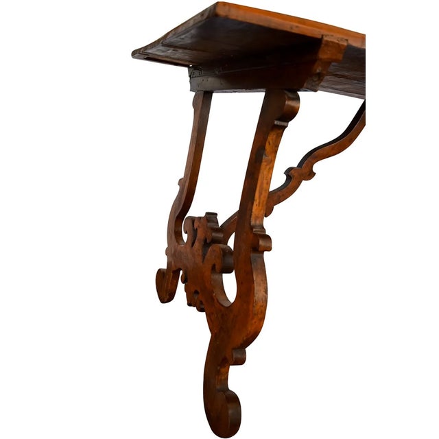 This 19th-century walnut table has stunning lyre legs. The piece is sturdy and could work as a console table or desk.