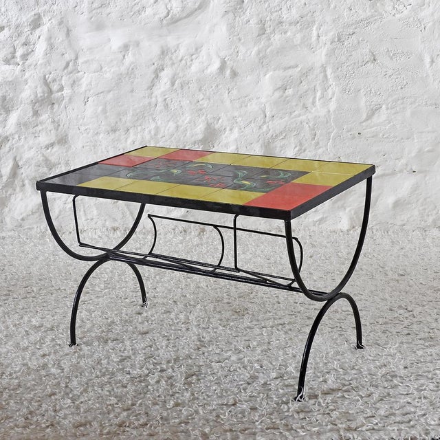 Beautiful coffee table with a ceramic top. Plain tiles in yellow, red, and black, with a black tile center decorated in...