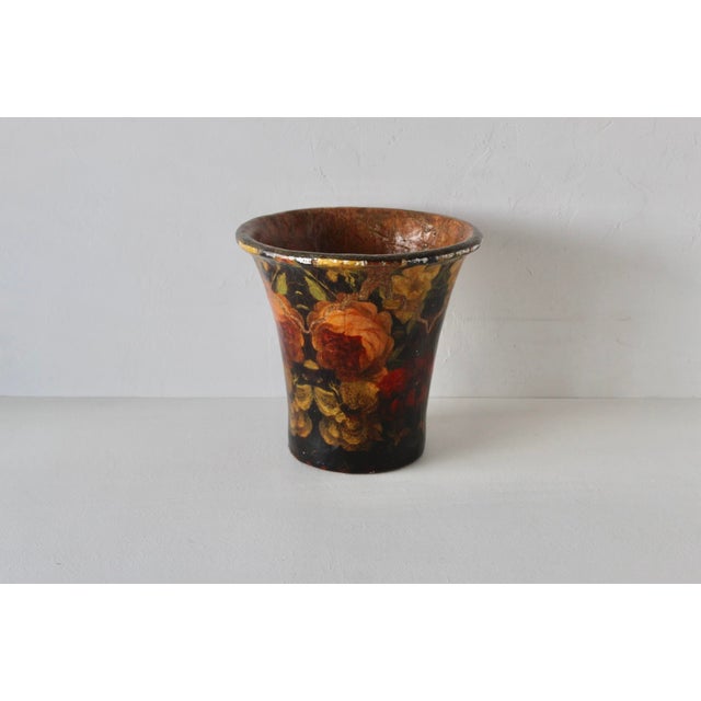 A large vintage decorative cachepot/wastebasket featuring a dark background adorned with vibrant decoupage floral motifs....
