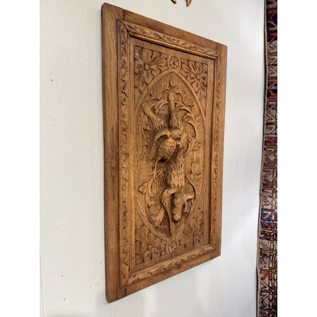 Hand-carved solid wood wall panel depicting a whimsical yet macabre dead rabbit motif in deep relief, framed by an...