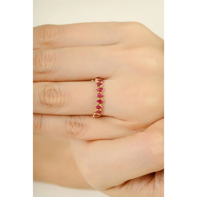 This elegant ring features pear shaped natural ruby, totaling 1 carats, bezel-set in 14K yellow gold. The ruby are...