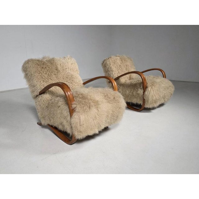 Jindrich halabala, lounge chairs. Model ‘h-269’, light brown stained beech, iceland curly sheepskin, circa 1930s. The...