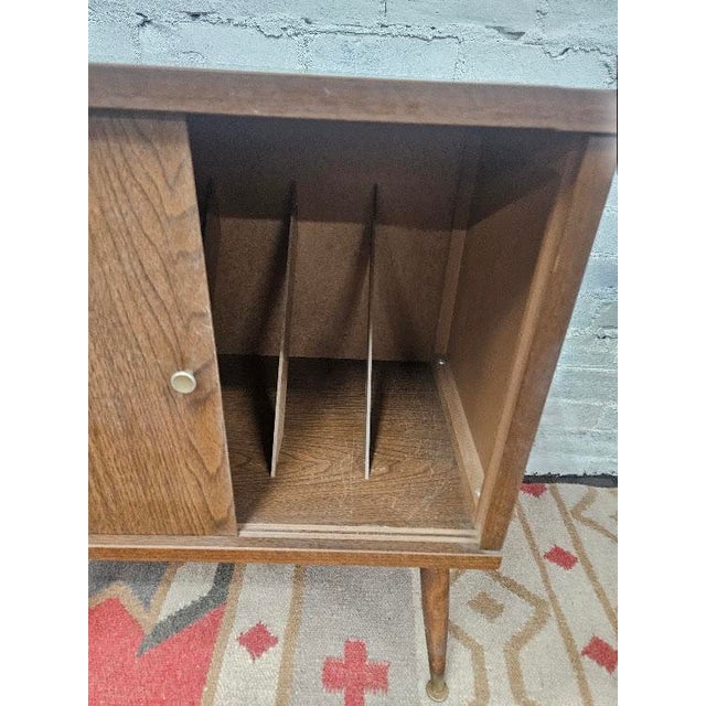 Mid-century style classic record cabinet by Lu Van Inc. Featuring , sliding cabinet doors, and iconic tapered legs, this...