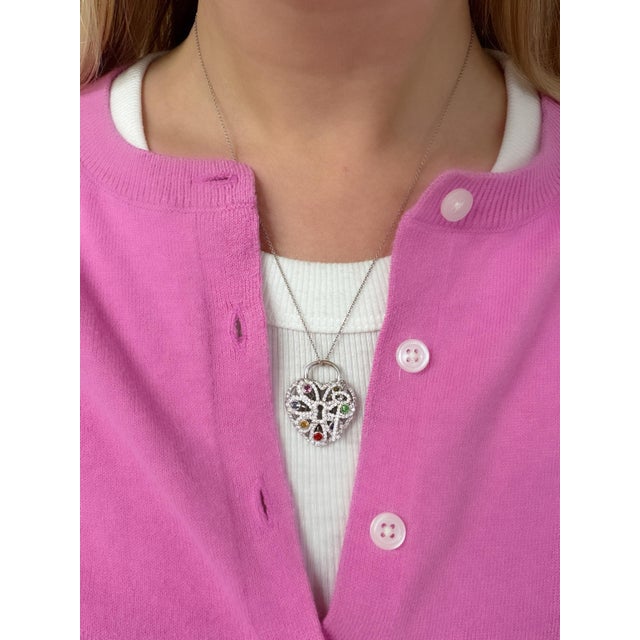 This stunning necklace is designed as a heart-shaped lock and key, the pendant set with round pink tourmaline, iolite,...