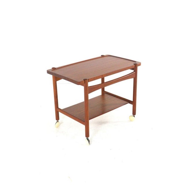 A beautifully designed teak trolley. This trolley owes its lovely, timeless look to the flowing lines in its design; both...