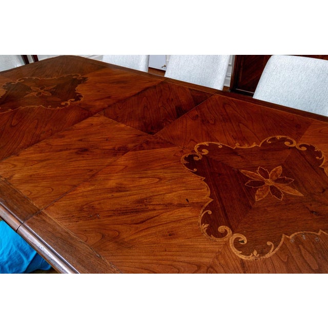 A large beautifully designed Spanish Continental style extension dining table in richly figured walnut with a clipped...