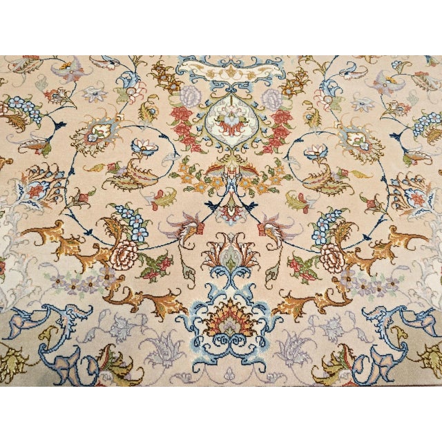 An exquisite example of Persian artistry, this authentic room-size Tabriz rug showcases a delicate floral design woven...