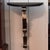 A wall mounted console with a demilune black marble top carried on a single steel bracket worked into a ribbon of deep...