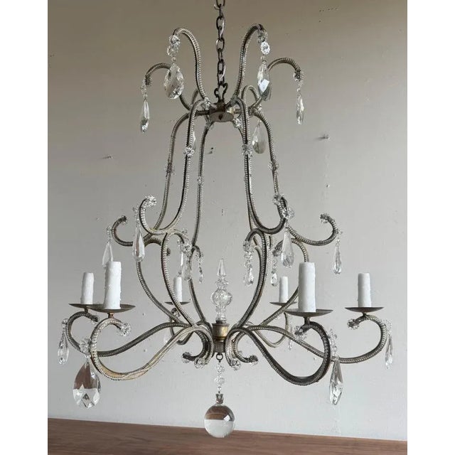 An elegant Italian crystal beaded chandelier, mid-20th century, featuring six lights on gracefully scrolled arms entirely...