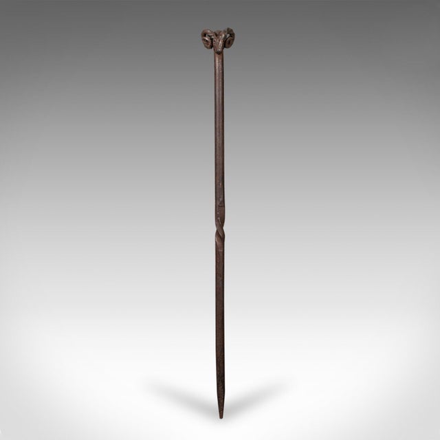 This is an antique ram’s head fire poker. An English, hand-forged wrought iron fireside tool, dating to the Edwardian...