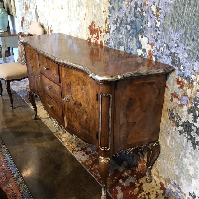 Shaped server with two doors, and three drawers with a distressed silver gilt edge detail featuring walnut oyster wood...