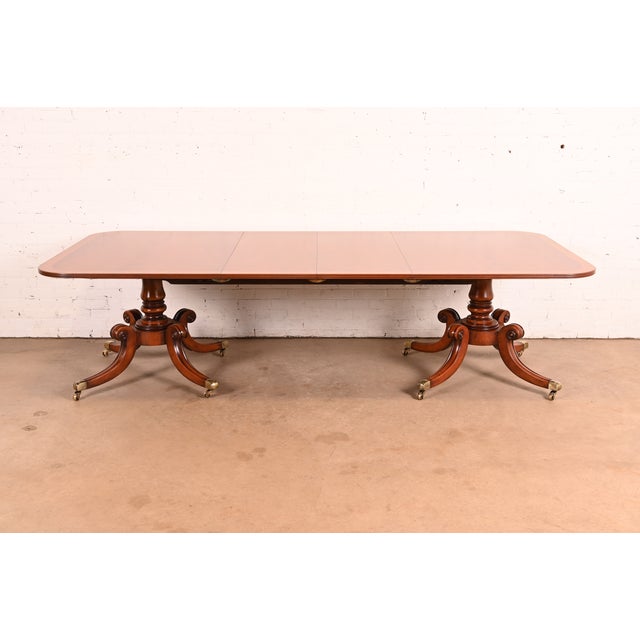 An exceptional Georgian or Regency style double pedestal extension dining table In the manner of Baker Furniture USA,...