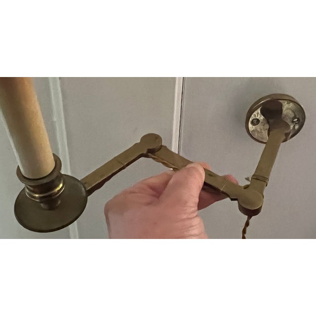 Brass swing arm library wall scone with single candle light, gold braided cord and white celluloid toggle switch. Round...