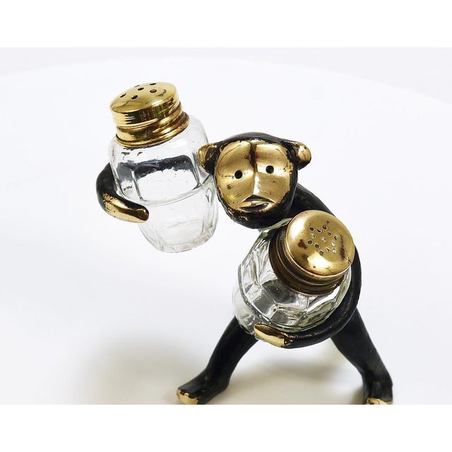 A charming Austrian midcentury shaker set from the 1950s, displaying a cute monkey holding salt and pepper shakers. A...