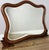 An elegant Antique French mirror with a beautifully flowing shaped frame, warm walnut finish and decorative carved scroll...