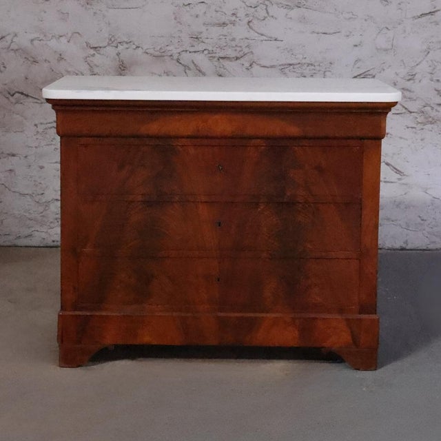 The 19th Century Louis Philippe Walnut Chest with White Marble Top is a timeless expression of French elegance and...