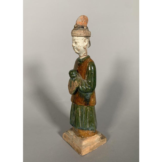 Sculpture of a Mingqi Servant, China, Ming Dynasty (1368-1644). Terracotta sculpture with green and brown glaze. Depicts a...