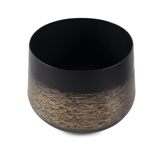 This vessel boasts a matte black exterior with delicate light golden etchings adorning its surface, intricately woven like...