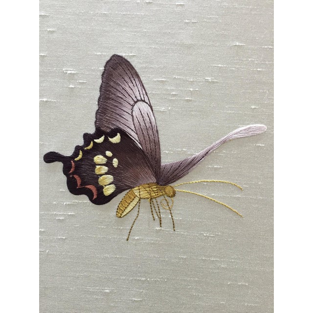 This hand painted wallpaper mural features delicate ginkgo leaves and graceful butterflies arranged across a soft neutral...