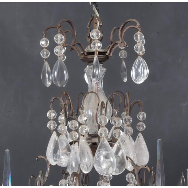 An elegant and elaborately ornamented Louis XV style sixteen-light chandelier, featuring a gracefully scrolling metal...