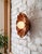 Bring warmth and character to any wall with this flower wall sconce, hand-carved from natural red travertine. Soft,...