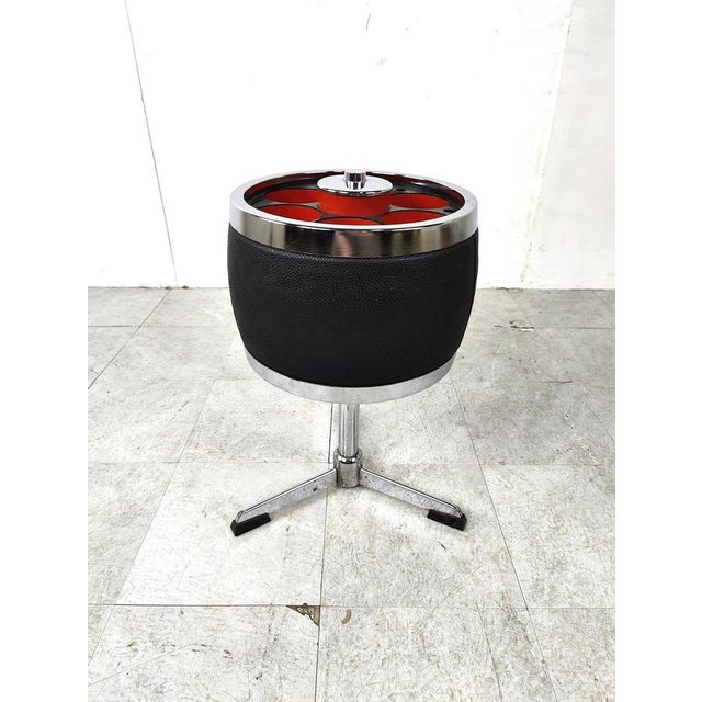 Vintage space age bottle holder side table with an organe and black plastic top and chromed base. Cool decorative piece....