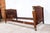 An early 19th century French Empire burl mahogany daybed with equal height headboard and footboard, plain paneled backs,...