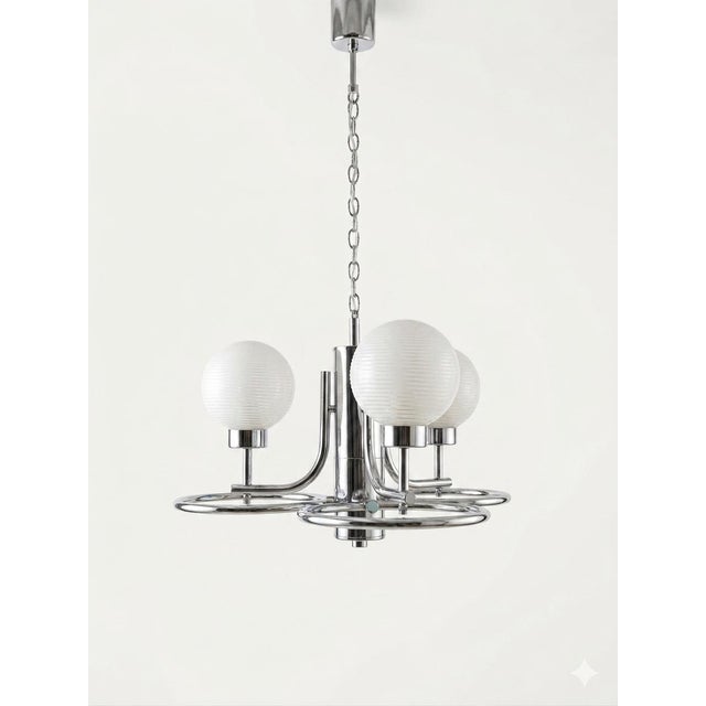 Space Age Hanging Lamp in Chrome Metal from the 1960s. It is characterized by its polished chrome frame and three opal...