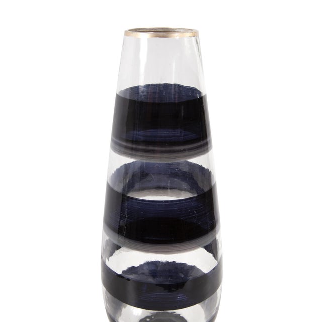 The Vector glass torpedo tall vase features a hand painted black swirl pattern and a simple gold touch on the rim to...