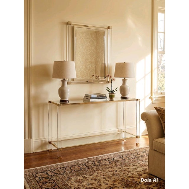A stylish Hollywood Regency infulenced wall mirror featuring a brushed brass metal frame with clean geometrice lines .The...