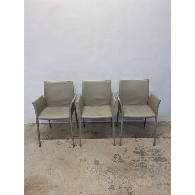 Set of three stone colored leather Lea dining arm chairs with leather wrapped seat and legs designed by Roberto Barbieri...