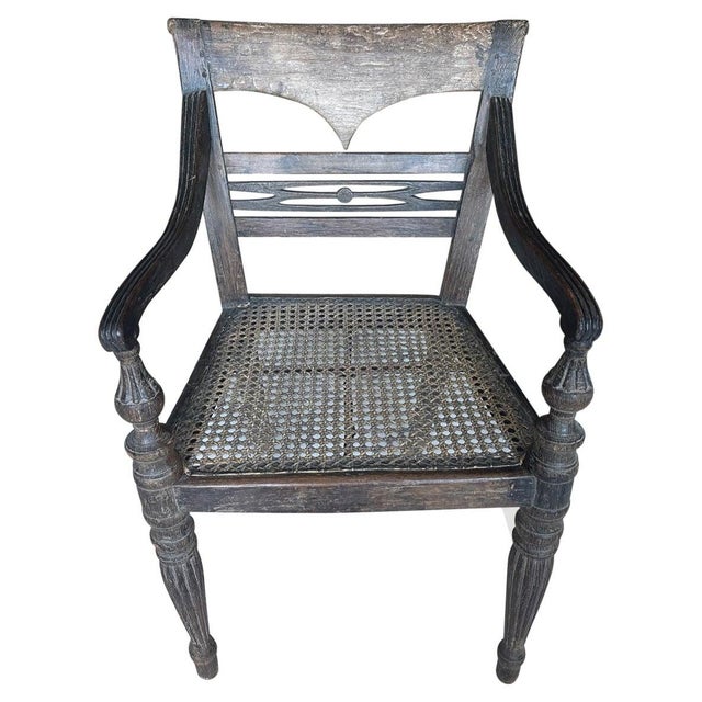 Stunning hand carved teak arm chair with beautiful patina. The front legs and arm rests are beautifully fluted and hand...