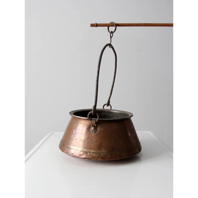 This is an antique copper kettle. The beautiful, heavy copper pot has an iron handle with a ring that was used to hang...